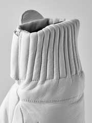 White wool mittens pair with ribbed knit cuffs and stitched leather palms