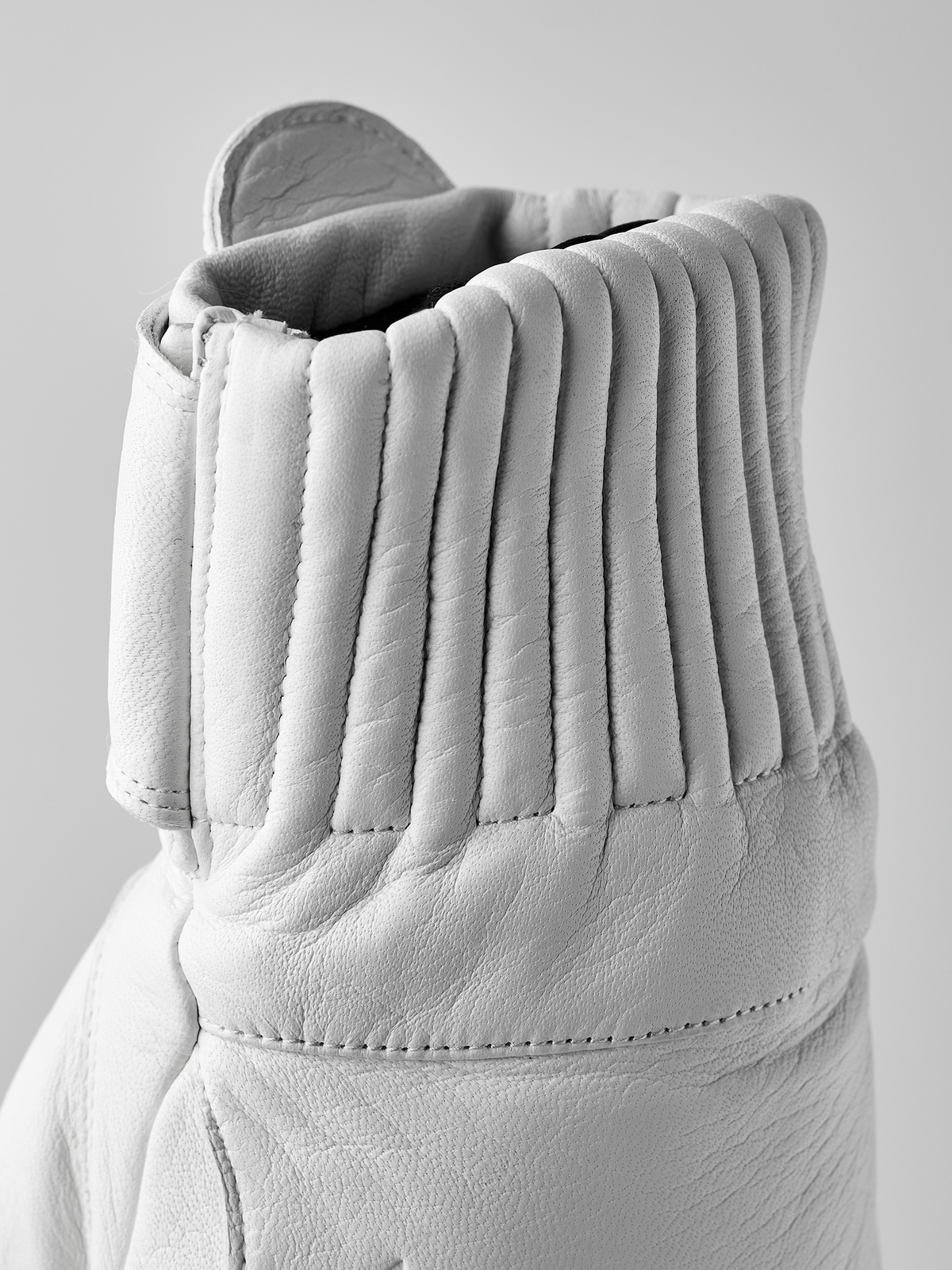 White wool mittens pair with ribbed knit cuffs and stitched leather palms
