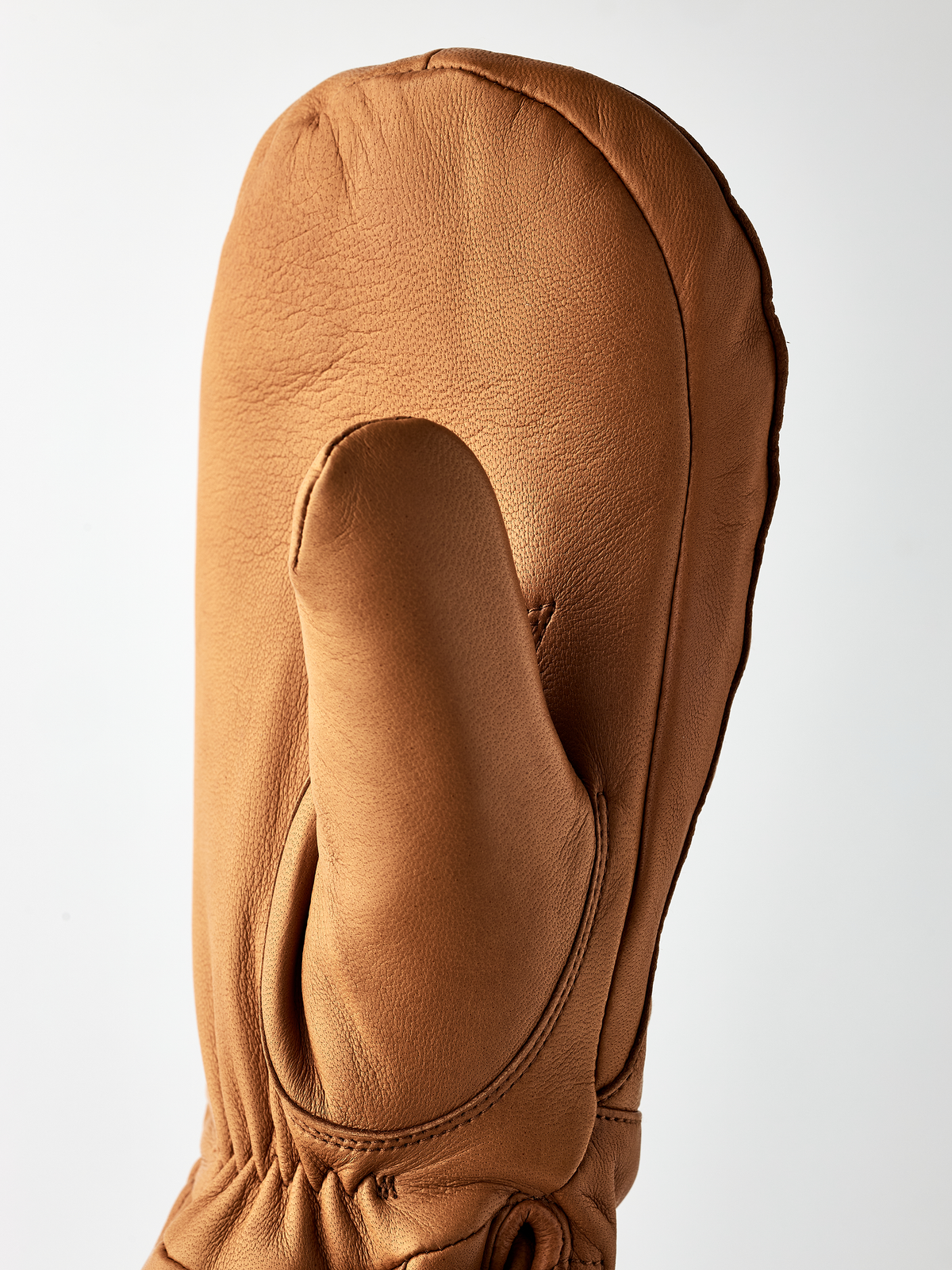 Brown wool mittens with textured leather exterior and oval thumb panel