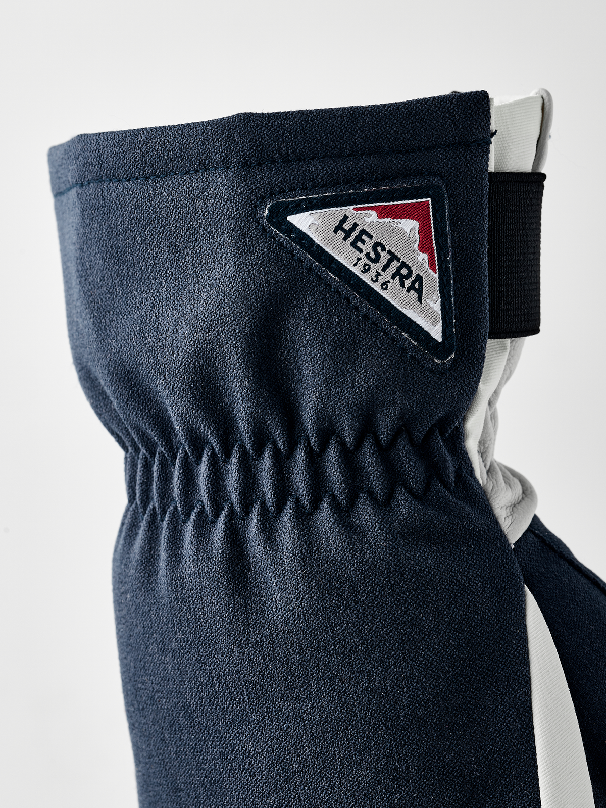 Navy powder short gloves with Hestra logo patch and elastic wrist cuff