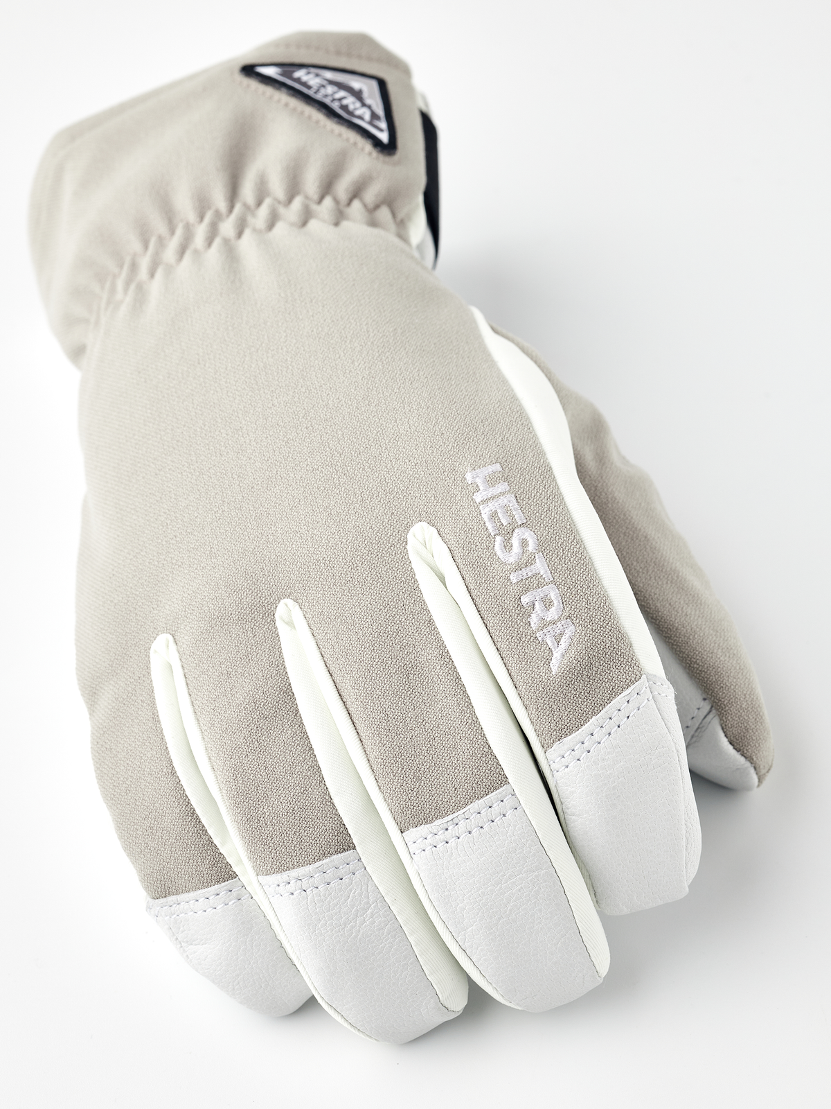 Beige and white short gloves with Hestra logo patch on back