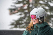 Giro ski goggles with pink mirrored lens and white frame worn on a helmet