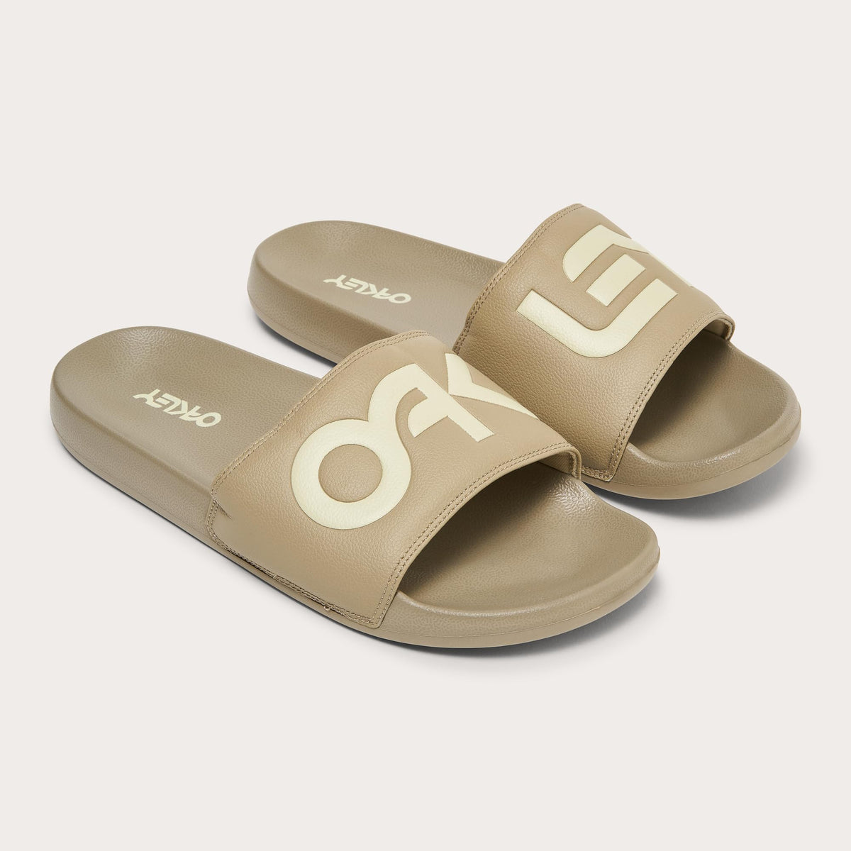 Men's slide sandals, tan upper with large white Oakley block lettering