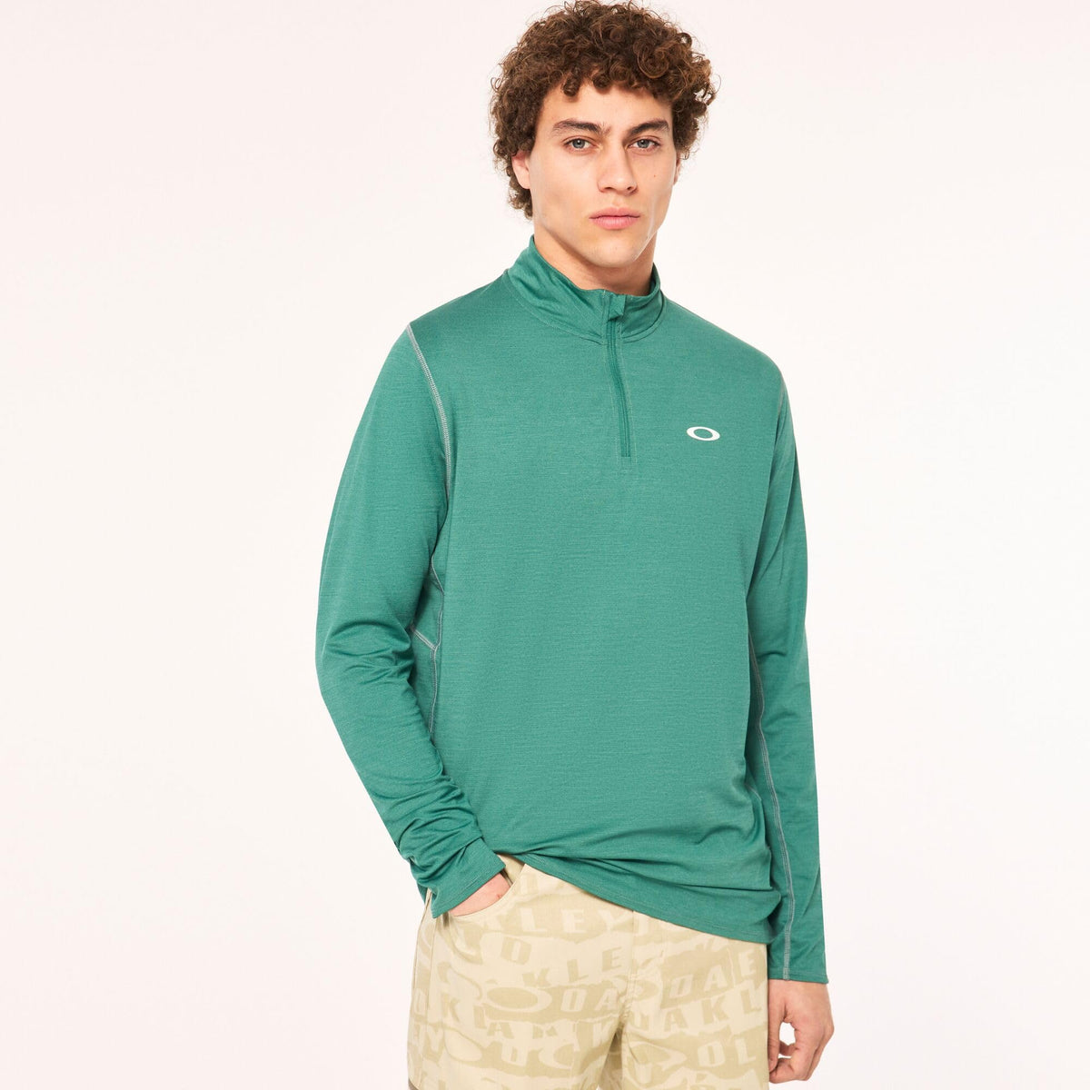 Green quarter-zip sweatshirt worn by model; stand collar and chest logo