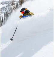 Black snow goggles with colorful reflective lens, worn while skiing