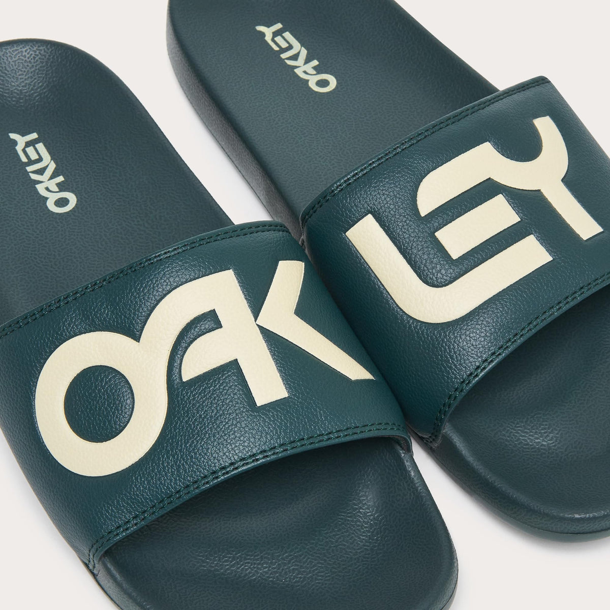 Men's slide sandals, teal straps with bold white Oakley letters and stitched edge