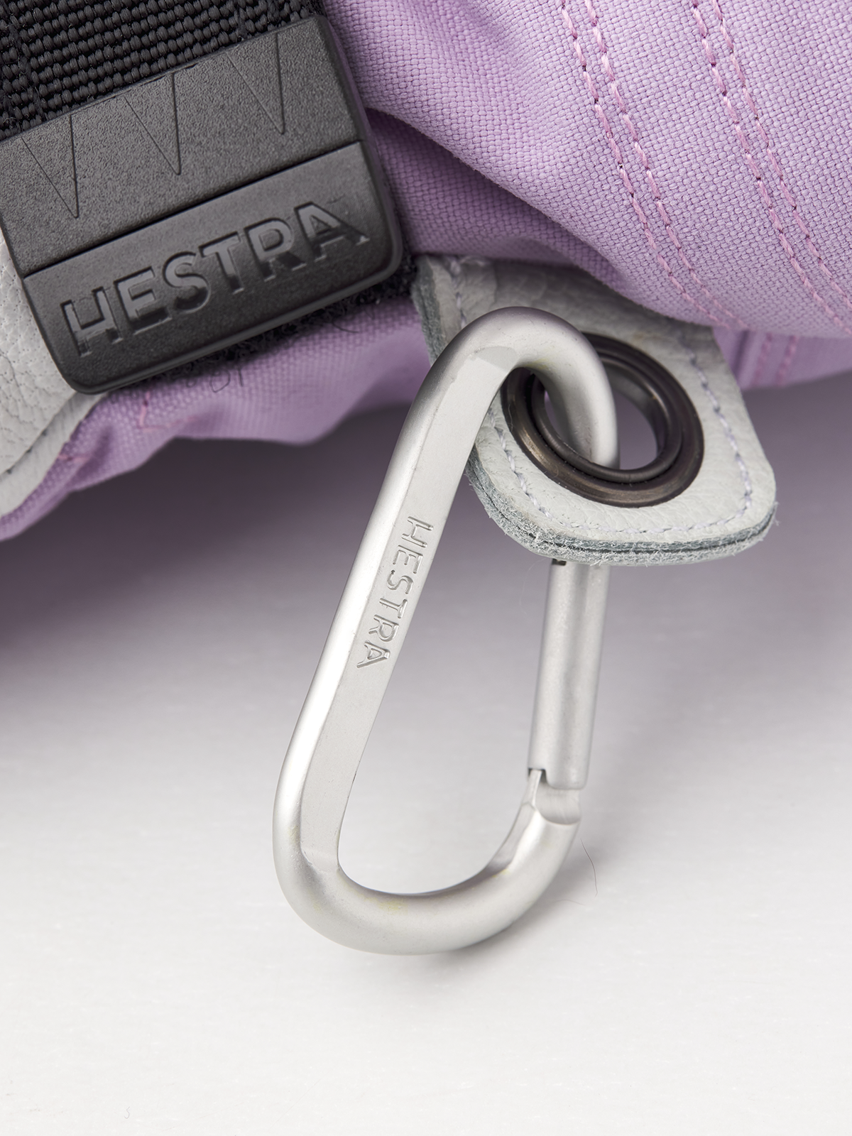Lavender ski glove with gray carabiner-style safety hook and strap