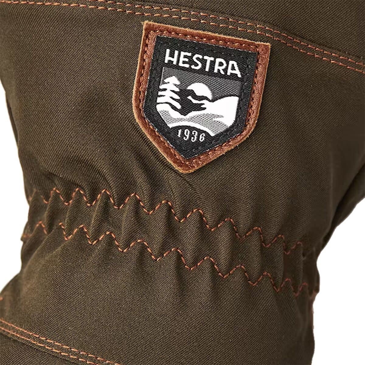 Brand patch and zigzag-stitched trim on dark olive gauntlet glove cuff.