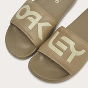 Men's slide sandals, close-up of tan strap with bold white Oakley logo