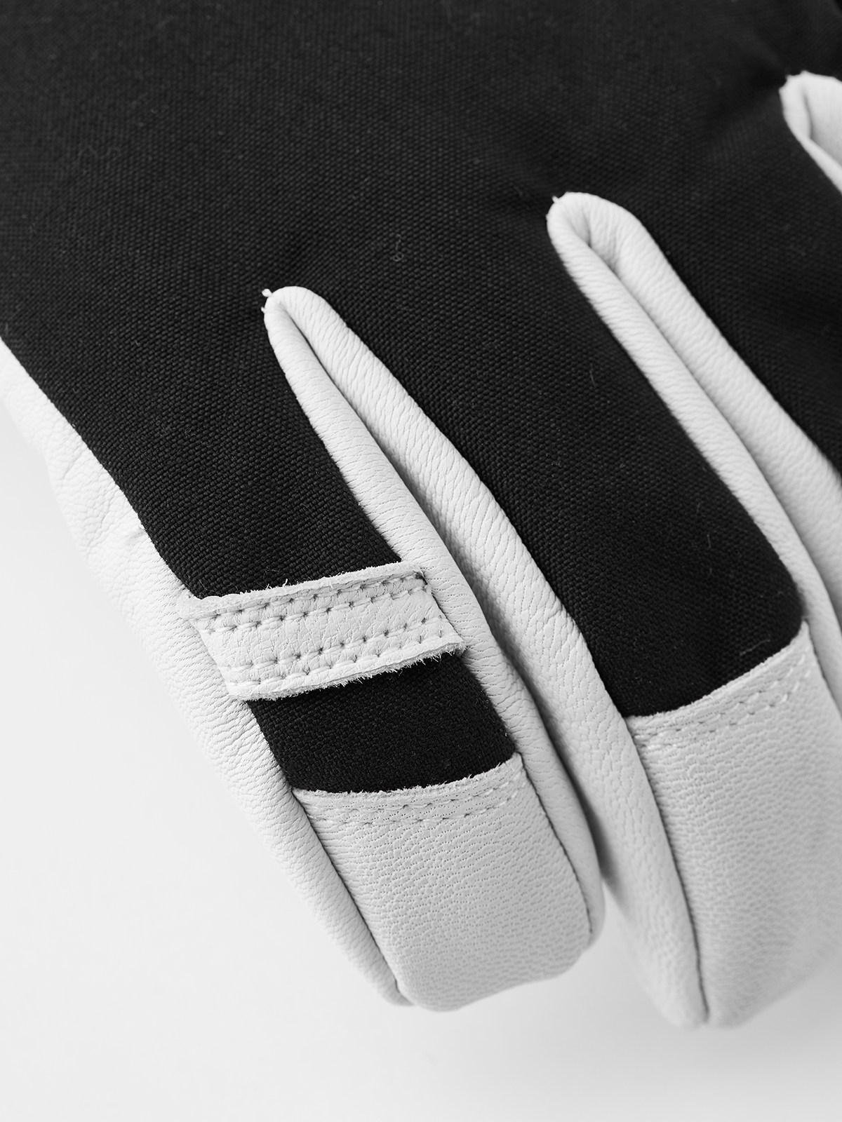Black and white ski glove with stitched finger panels and split thumb section