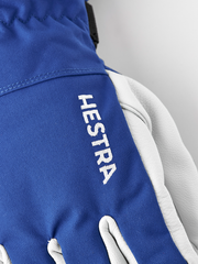Royal blue ski glove with Hestra logo on the wrist and white leather interior.