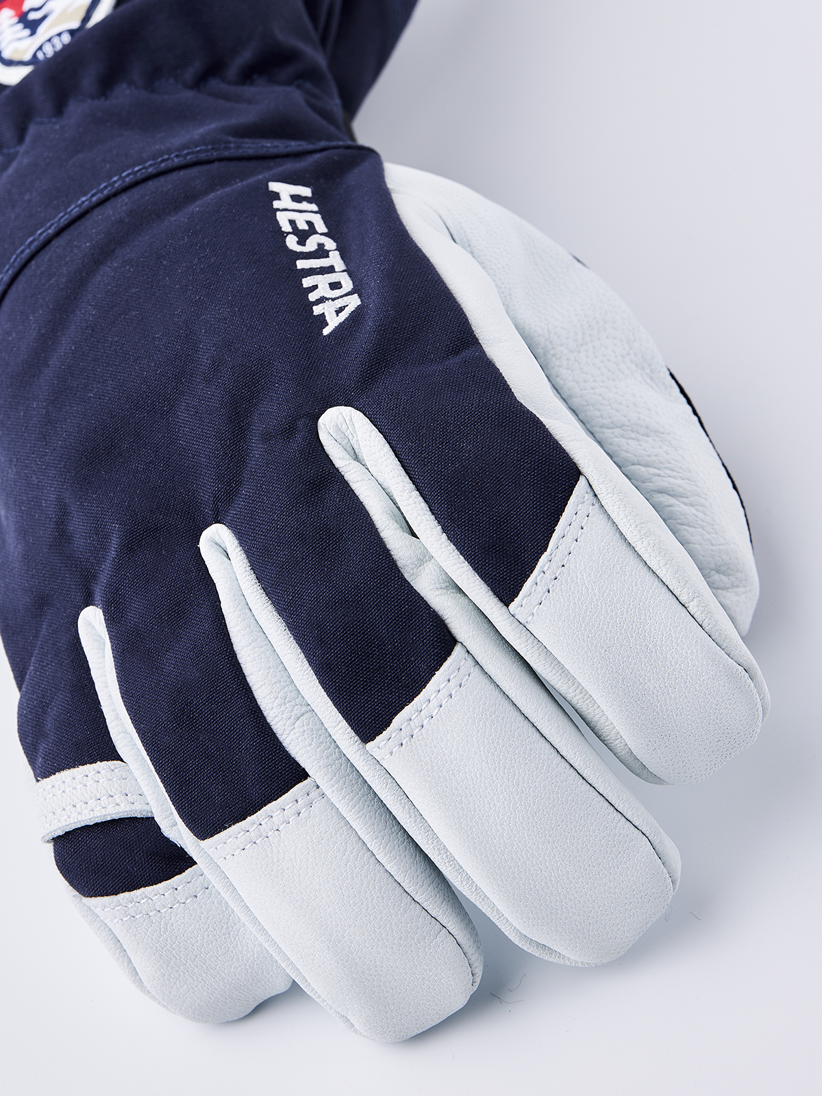 Navy ski gloves with light blue leather palms and white contrast stitching