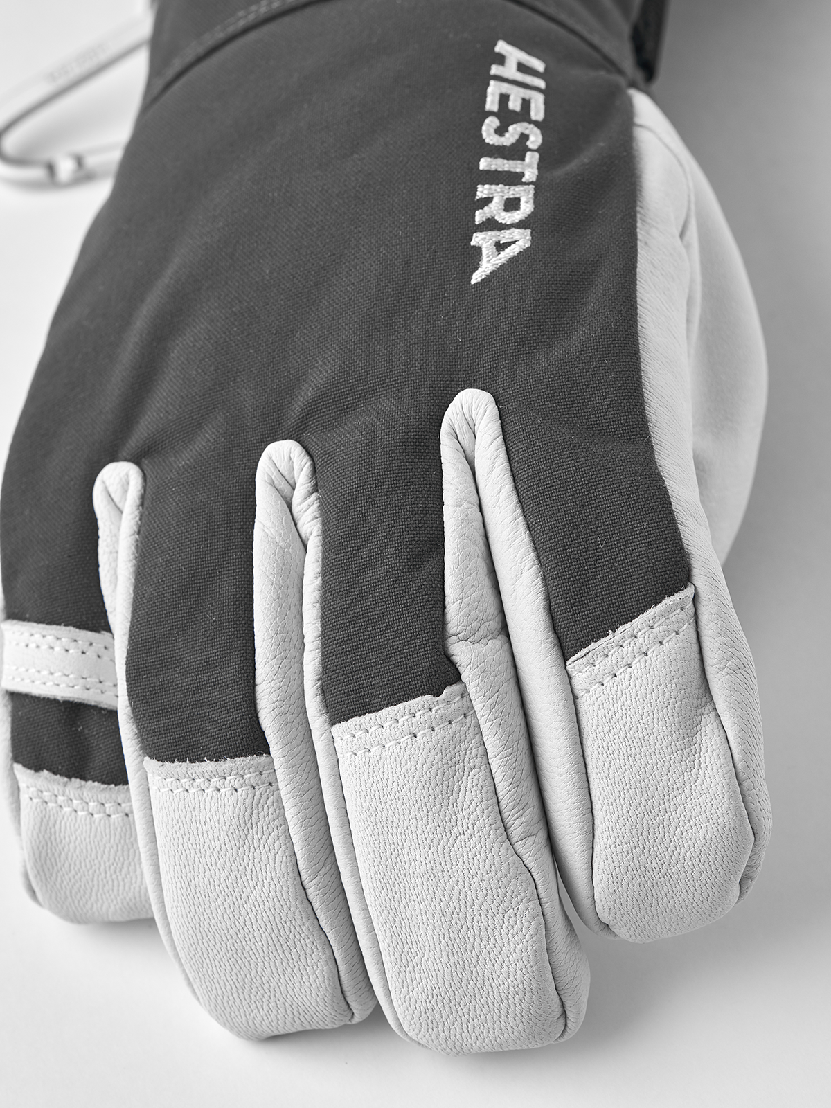 Dark gray ski glove with white leather palm and HESTRA logo on back