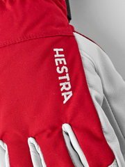 Red ski glove with Hestra logo print and white leather backhand panels.