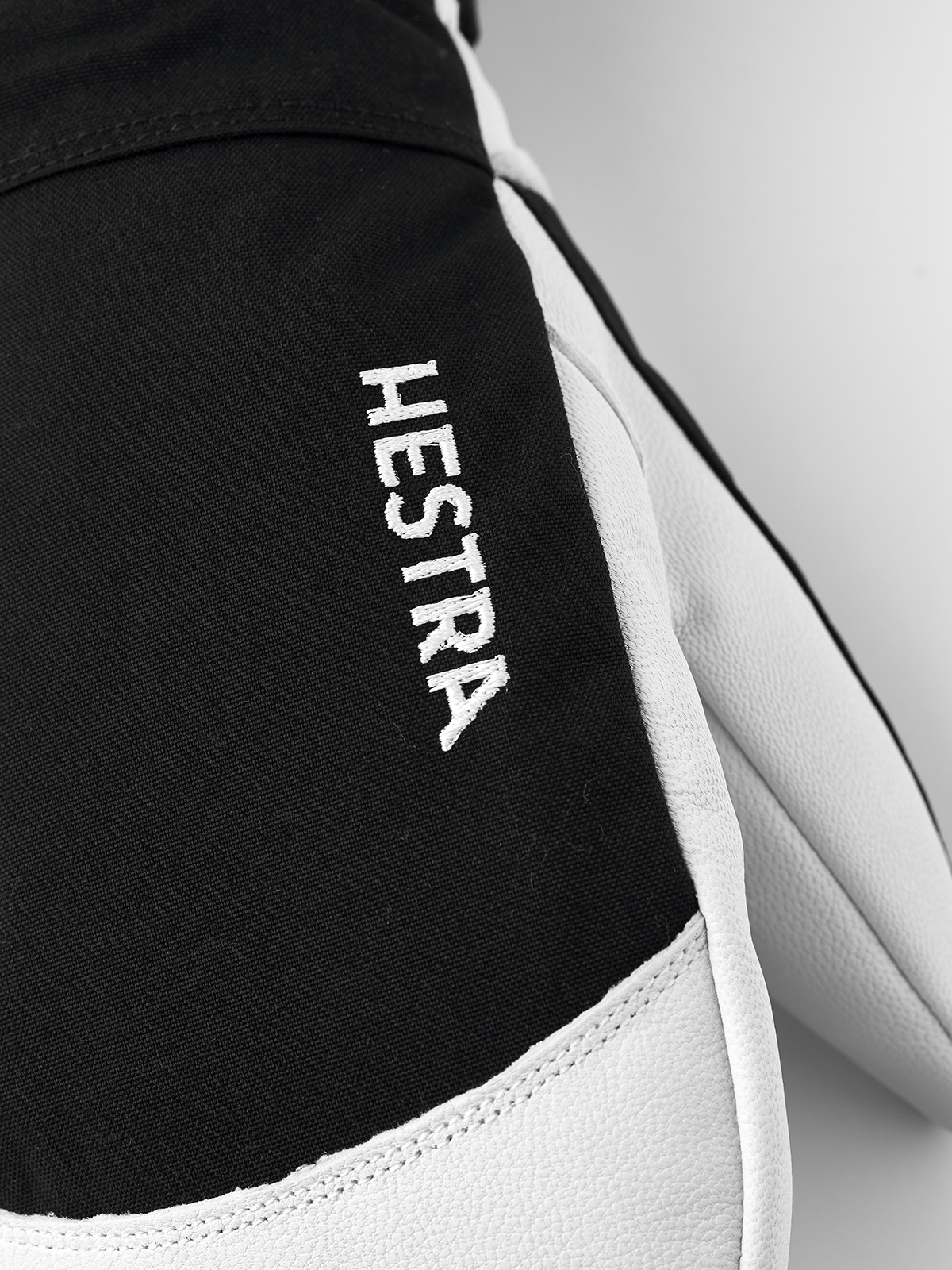 Black Hestra ski glove with white leather trim and HESTRA logo on cuff