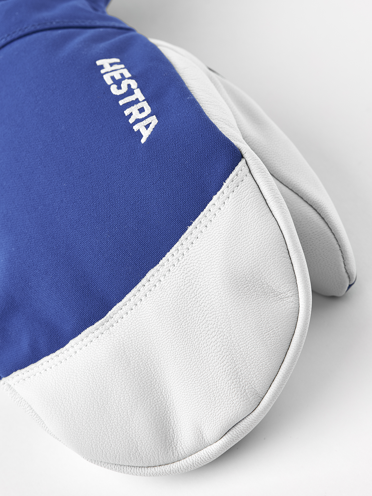 Blue and white ski mitten with white leather palm and stitched cuff edge