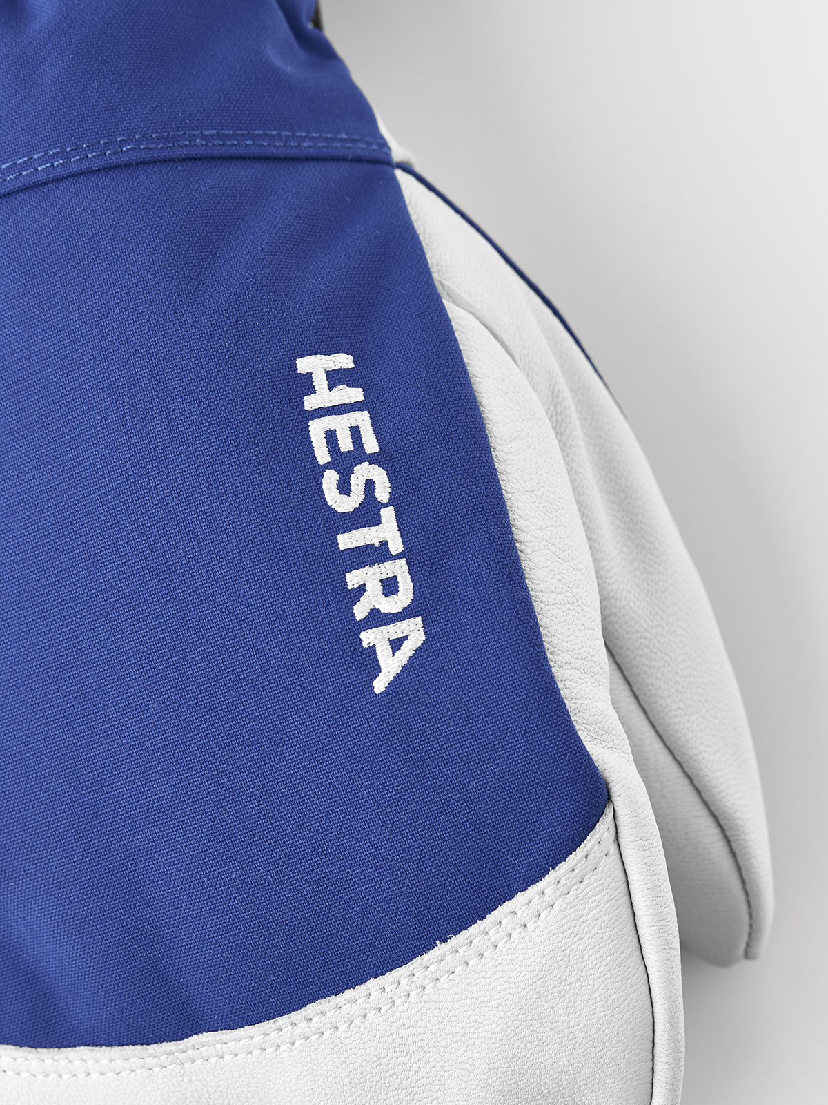 Blue ski mitten cuff with embroidered HESTRA text and white leather trim