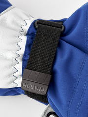Blue and white Hestra ski mittens with black adjustable wrist strap and logo tab