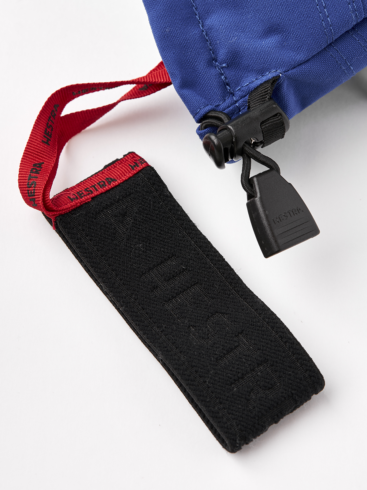Black ski mitten cuff strap with label, shown with red and blue wrist panels