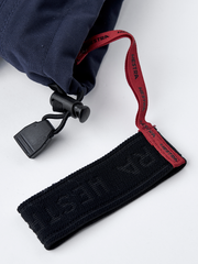 Wrist strap with red HESTRA lettering and black textured pull tab on mitten
