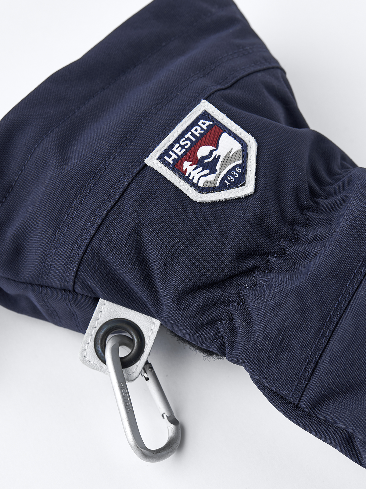 Navy ski mitten with Hestra patch and carabiner clip on the cuff