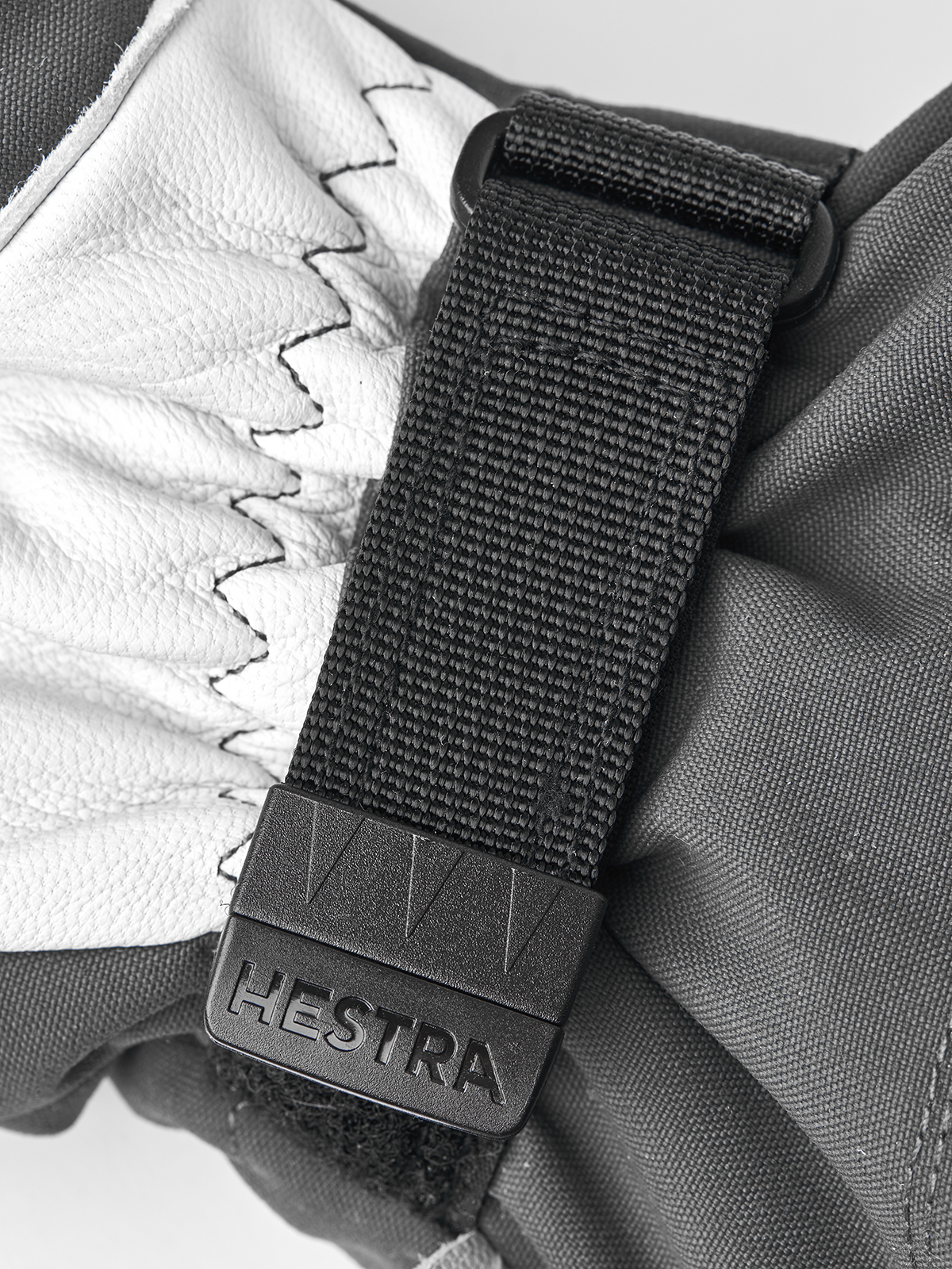 Black and white ski mitten with textured strap and Hestra wrist label
