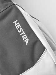 Grey ski mitten with white leather palm and Hestra logo text on fabric
