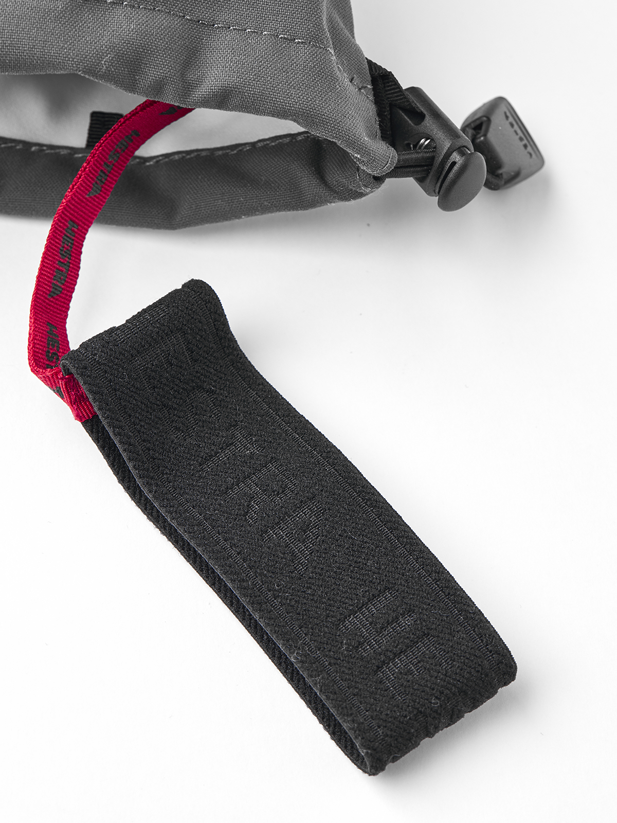 Brown Hestra ski mittens with red lining and black cord lock at wrist