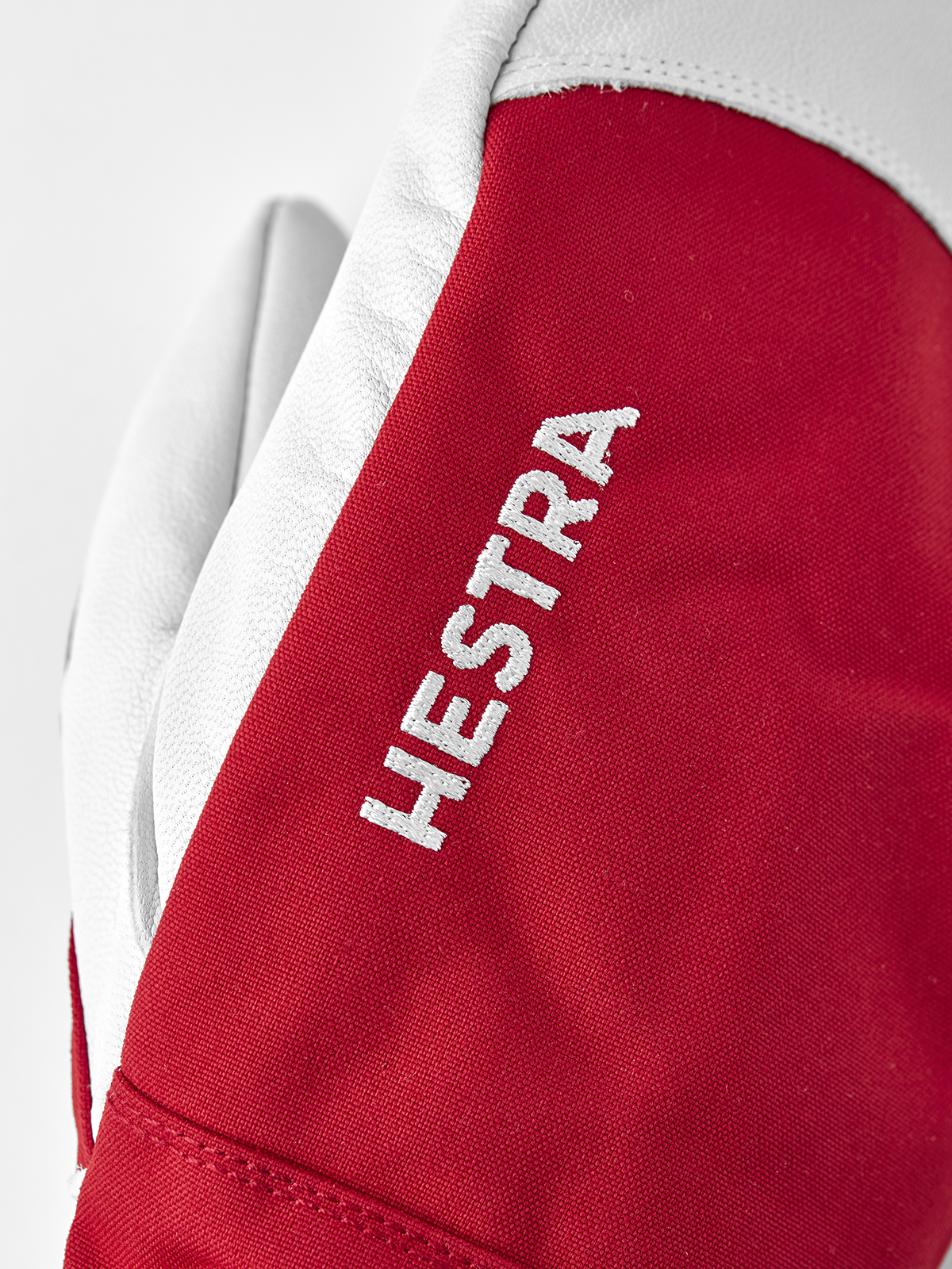 Red ski mitten with white leather cuff and HESTRA logo patch