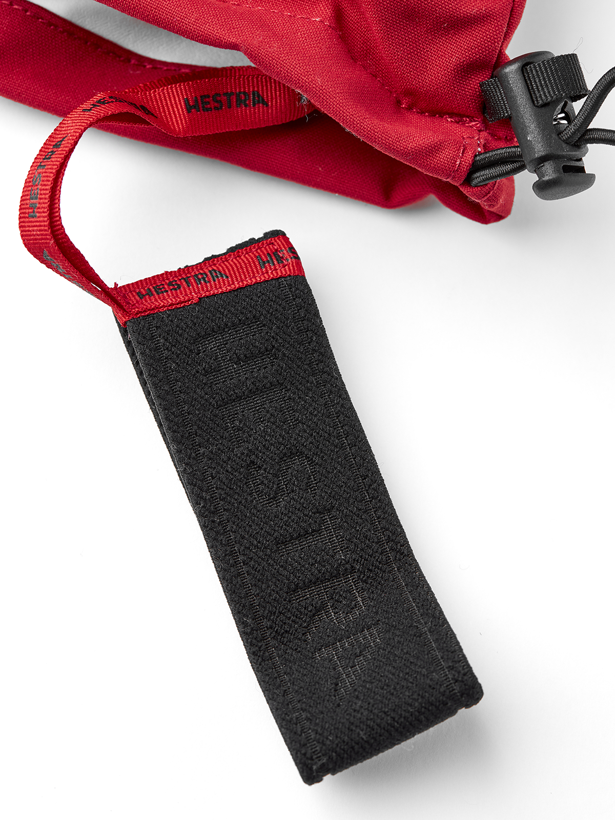 Red ski mitten wrist strap with black fabric panel and black plastic clip