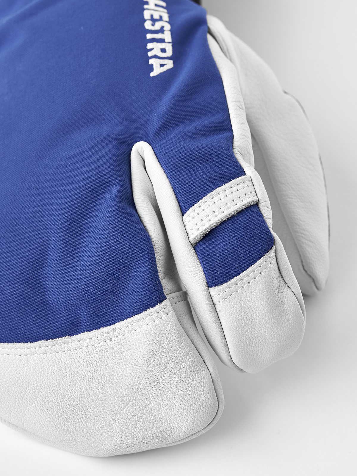 3-finger ski gloves in blue with white leather palms and padded mitten-style fingers.