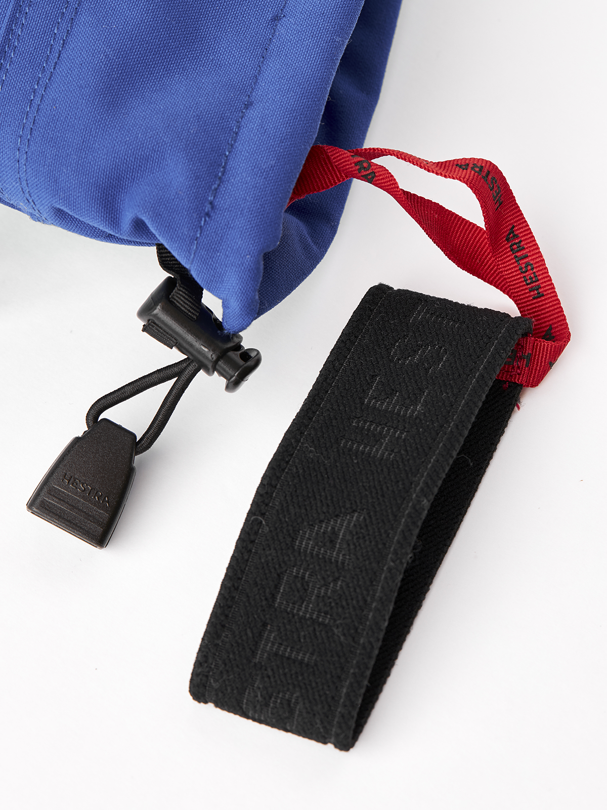 Royal blue Hestra ski glove with black and red strap and carabiner clip