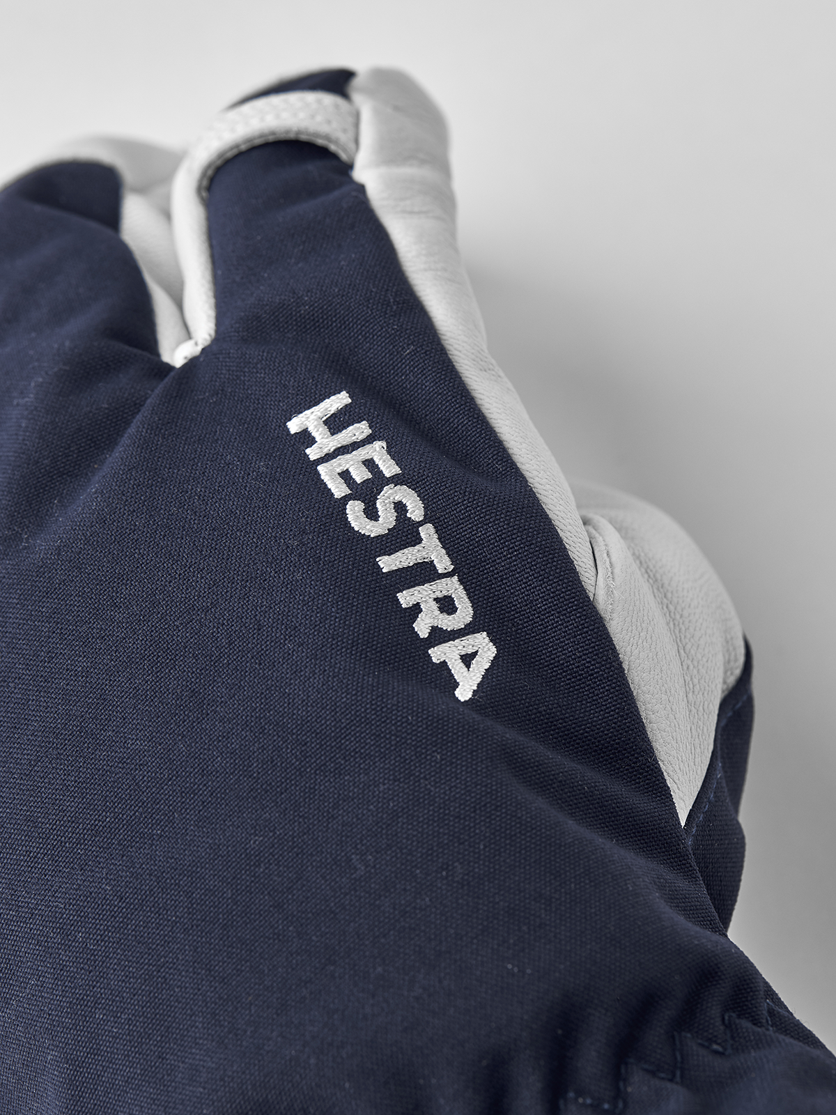 Navy 3-finger ski gloves with white Hestra print and white leather finger area