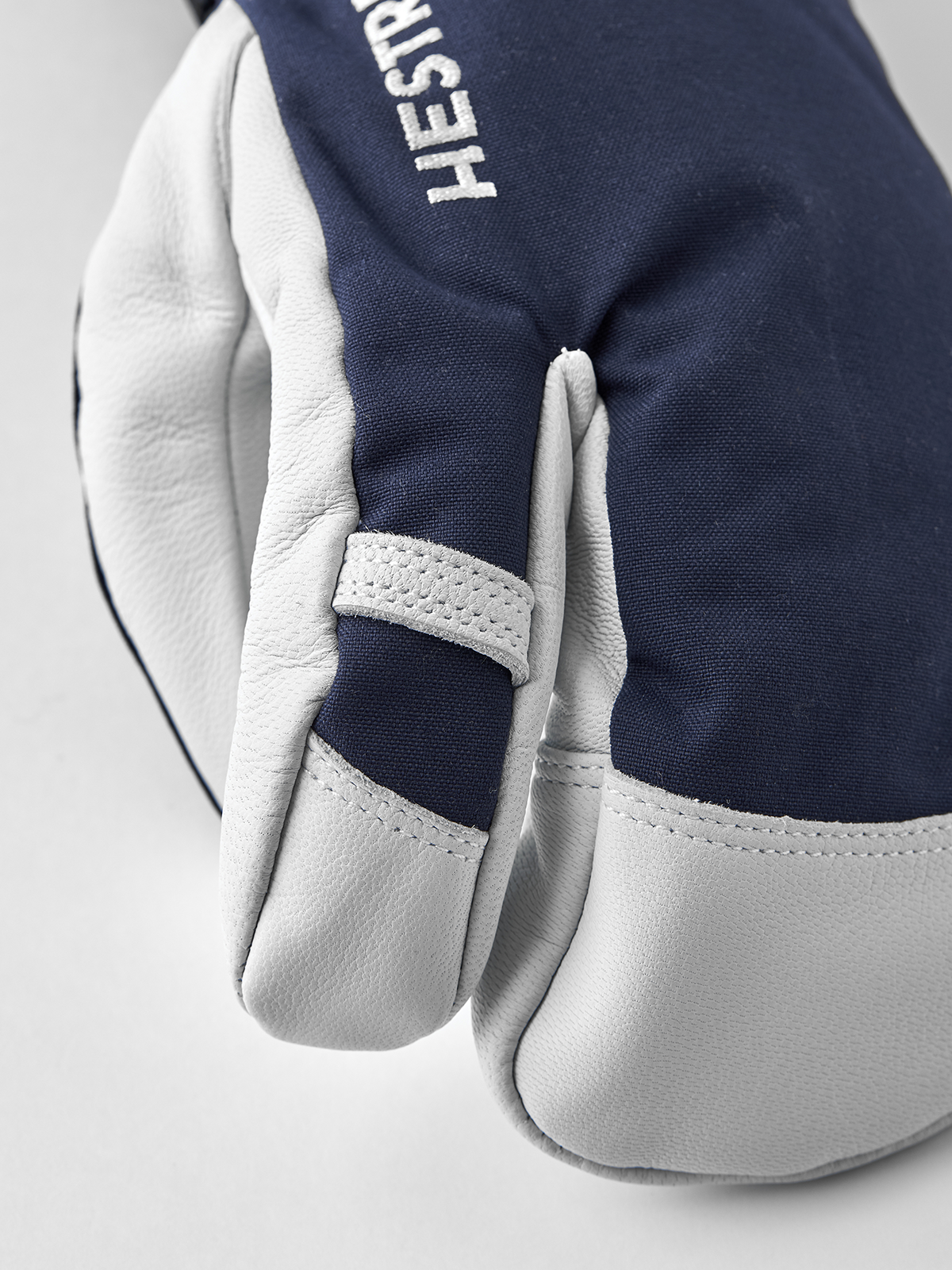 3-finger ski glove with navy fabric back and white leather fingertips and palms.