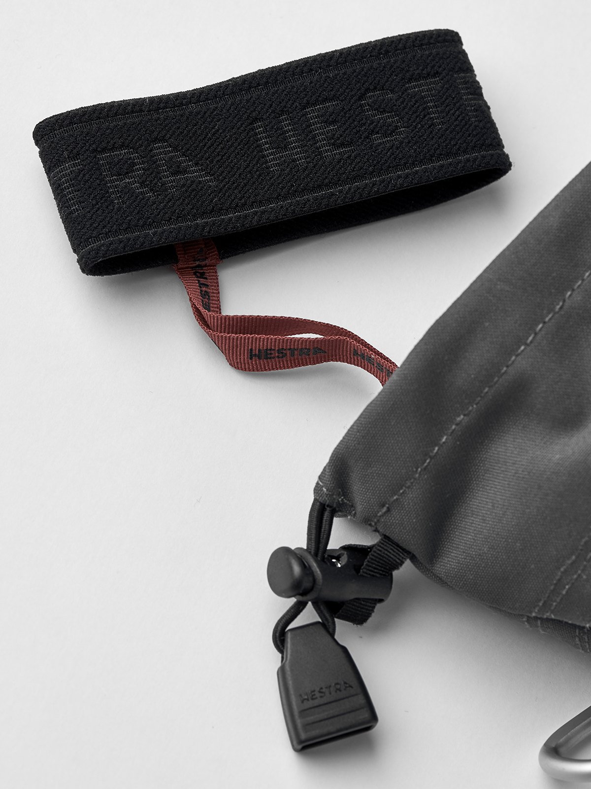 Black 3-finger ski glove cuff with adjustable strap and grey leather pocket