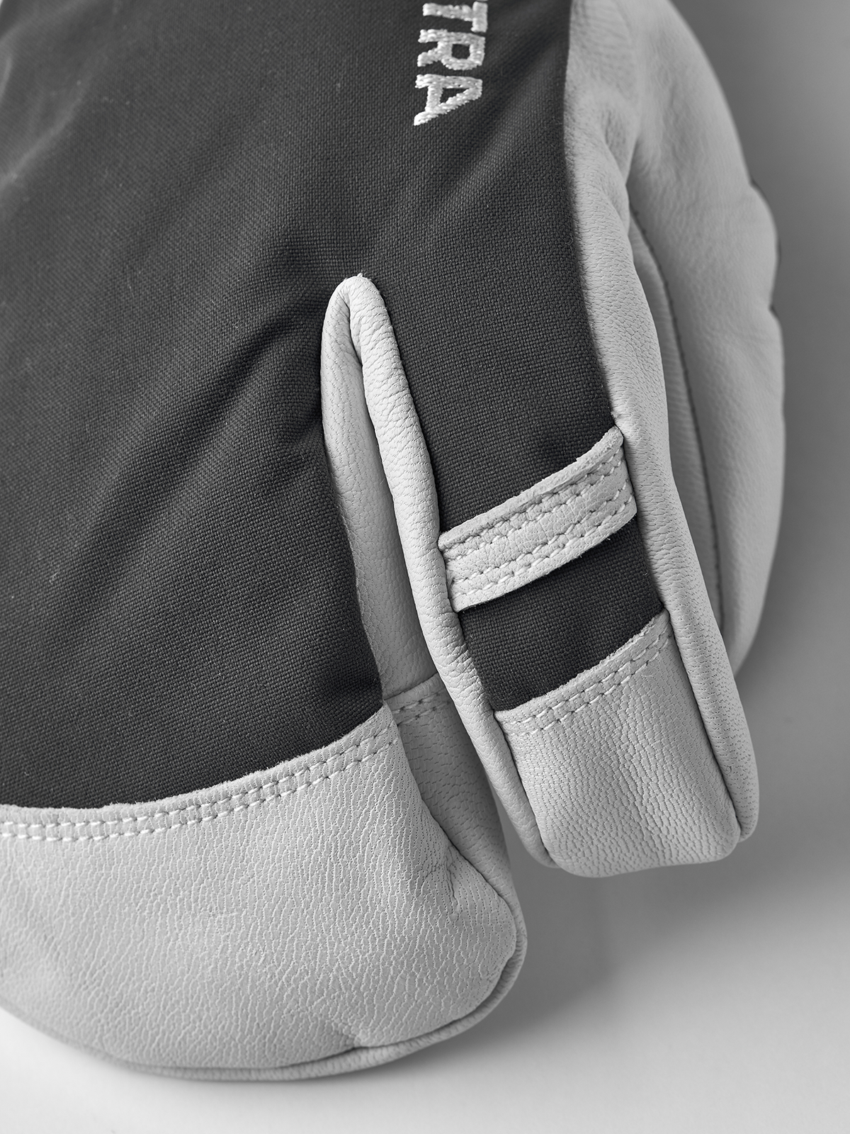 3-finger ski gloves in dark grey with white leather palm panel and stitched trim.