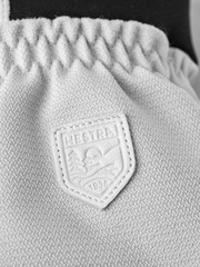 Light-colored patrol glove with textured knit cuff and Hestra shield logo patch