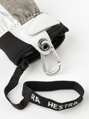 Leather glove cuff with carabiner clip and black wrist strap labeled Hestra