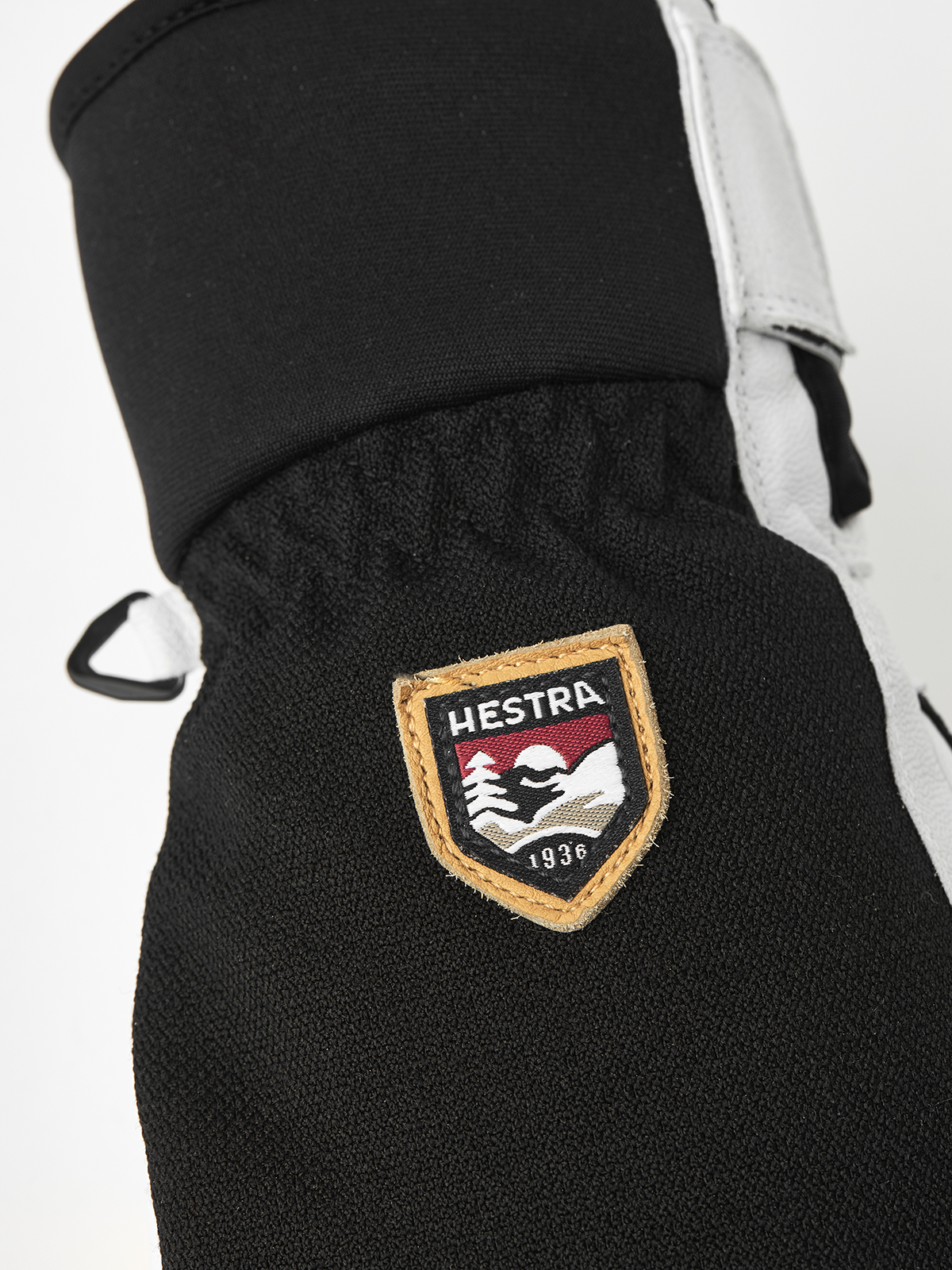 Black patrol glove with Hestra shield patch on knuckle panel.