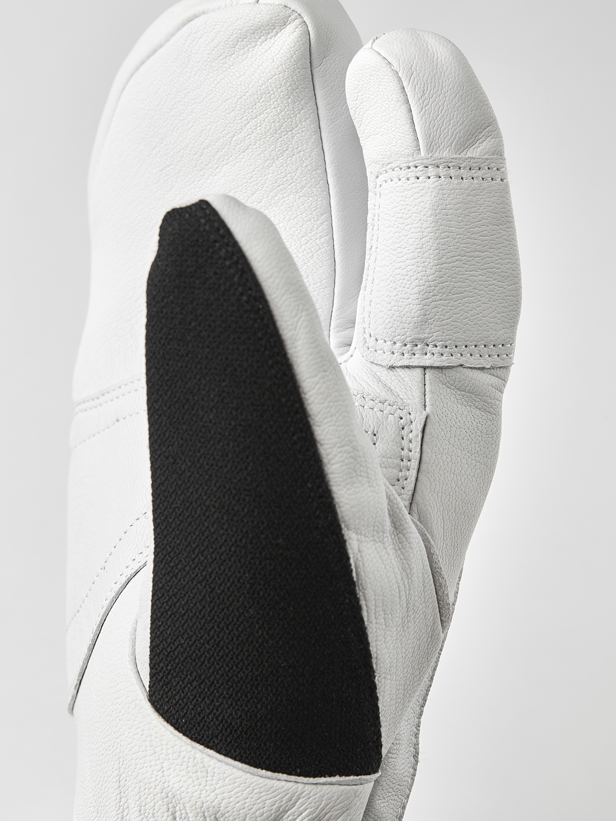 White 3-finger leather glove with black inner panel detail and stitched thumb