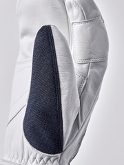 White 3-finger leather glove with navy textured panel and curved finger seam