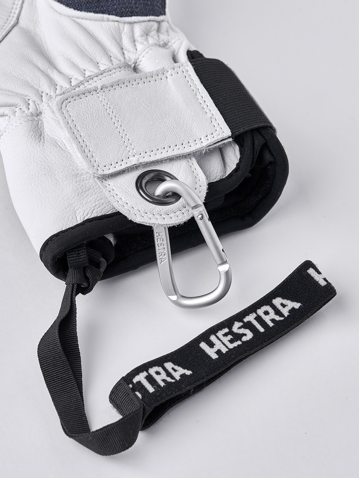 White glove wrist strap with metal carabiner and black branded elastic band