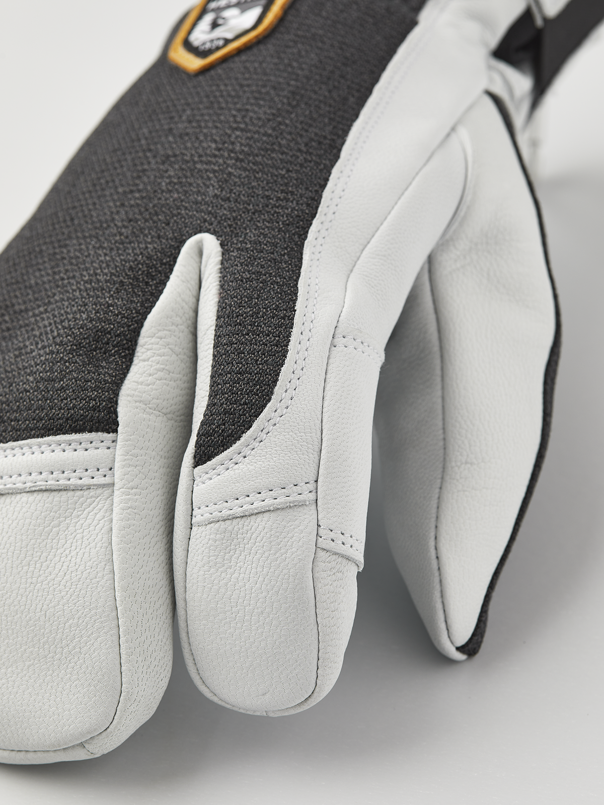 White leather glove fingers with stitched detail and tapered cuff.