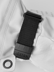 White ski glove with black webbing wrist strap and gray Hestra buckle