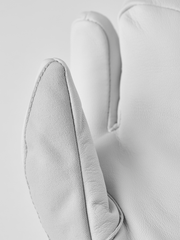 Off-white ski glove with textured thumb and side seam detail