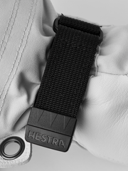 White glove wrist strap with black Hestra logo buckle and woven fabric tab