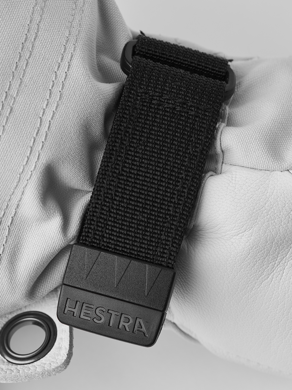 White glove wrist strap with black Hestra logo buckle and woven fabric tab