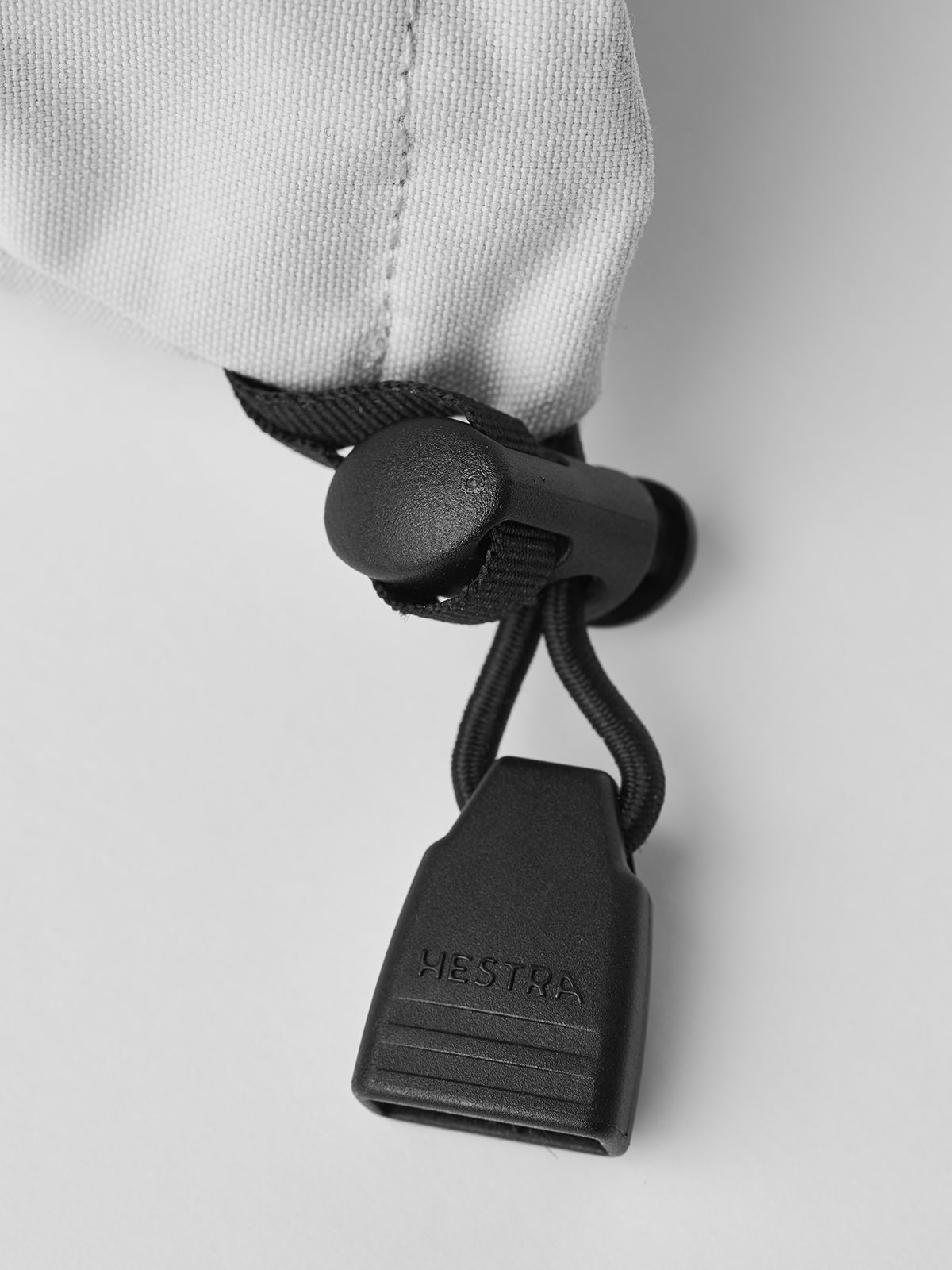 White ski glove wrist closure with black drawcord and Hestra logo tag