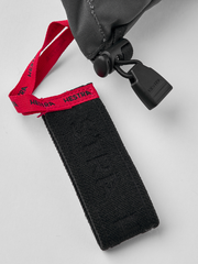 Black ski glove strap with red branded tag and textured fabric cuff