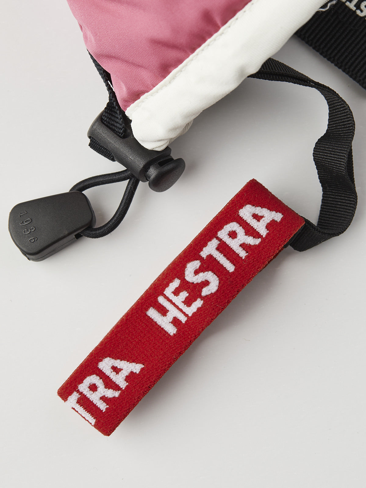 Kids glove wrist strap with red Hestra label and black pull loop